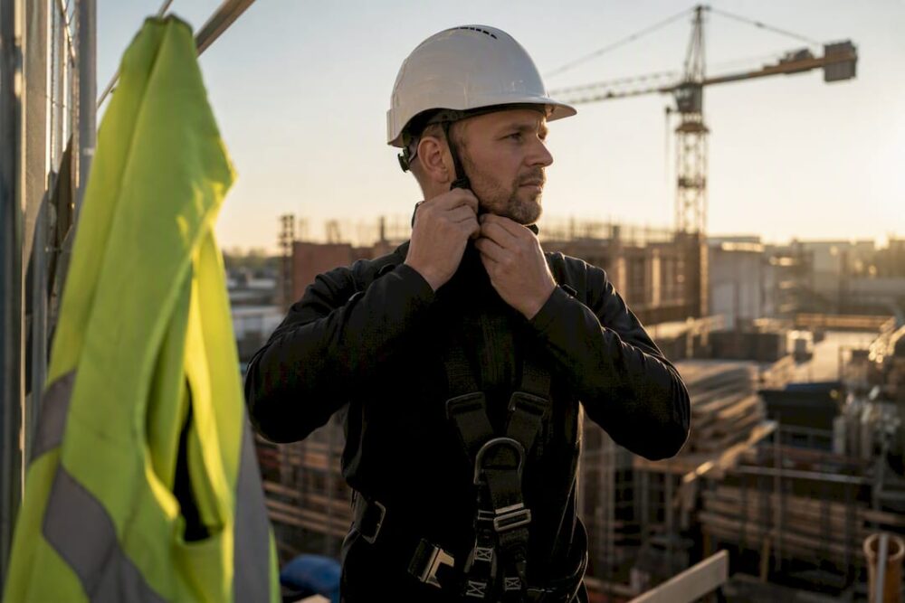 Händer som justerar en industrisäkerhetsele