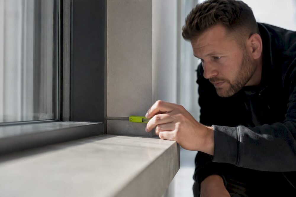 Besiktningsman undersöker byggnadsdetalj