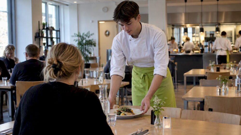 Elev på restaurangskolan serverar lunchgäster